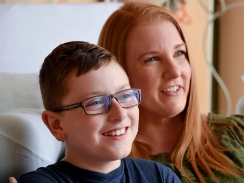 A woman and her son smiling.