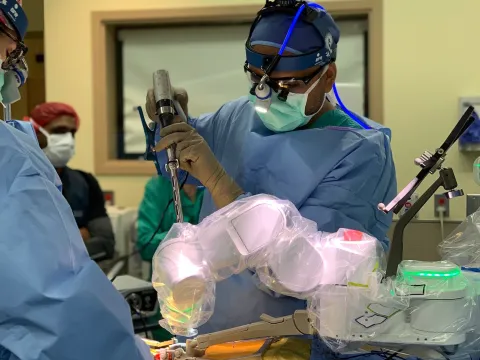 A doctor is using a robotic tool to conduct surgery.