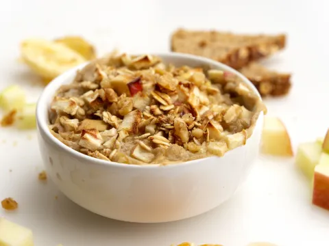 Bowl of cooked apples and oat with apple chunk garnish