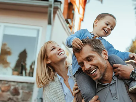Smiling Parents with Son on Father's shoulders outdoors