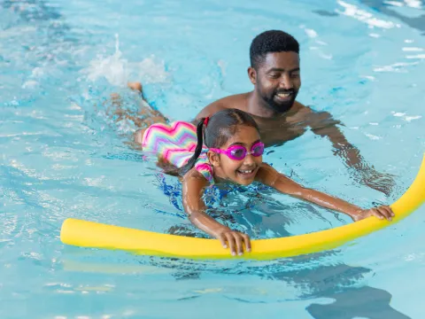 Father and Daughter swimming together at the pool.
