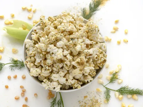 White bowl of seasoned popcorn on white counter