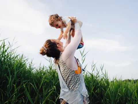A Mother Holds Her Son to the Sky in a Corn Field