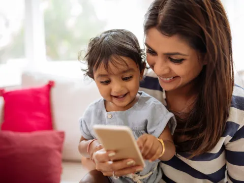 Mother and child using phone at home.