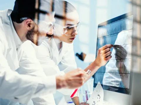 Two Physicians Look Over Test Results While in Scrubs