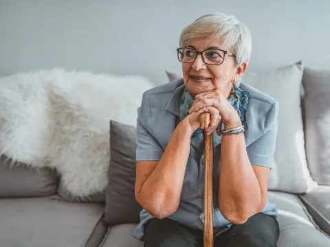 A woman sitting on her couch thinking.