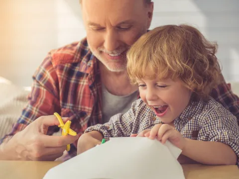 A father doing a craft project with his son.