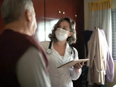 A female doctor talking to her senior patient