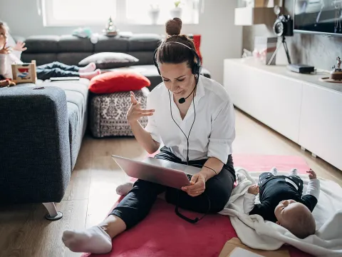 Woman working from home while she's with her children.