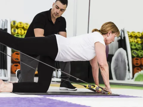 A woman doing a core exercise with a trainer.