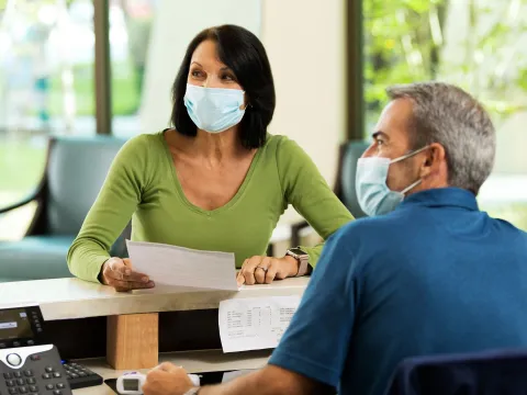 A woman getting help by a receptionist at AdventHealth Winter Park