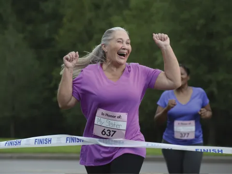 A senior woman crossing the finish line in a race