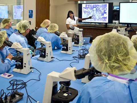 Professionals listening to a lecture in a Nicholson Center Lab Boardroom.
