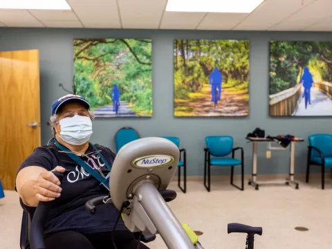 A patient using a cycle machine in the sports rehab room