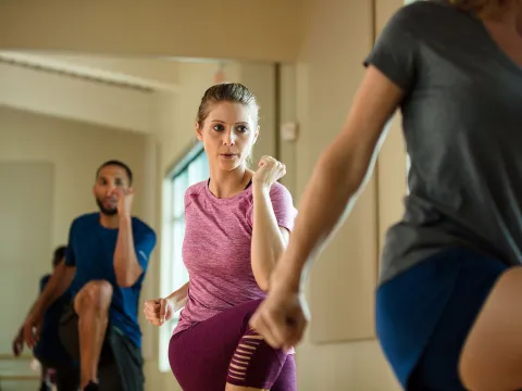 A group of people exercising at the gym while doing a group class.