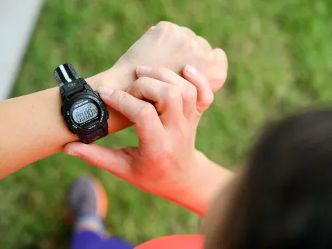 A man looking at his watch while exercising.