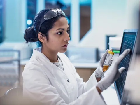 Physician in lab reading screen