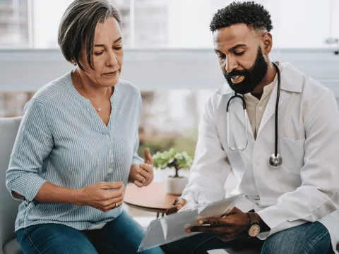 A middle-aged woman speaks to her doctor.