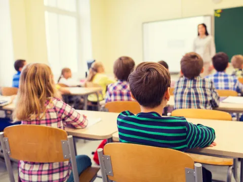 Children sitting in chairs in their classroom.