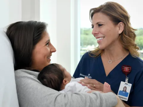 provider smiling at patient holding a baby