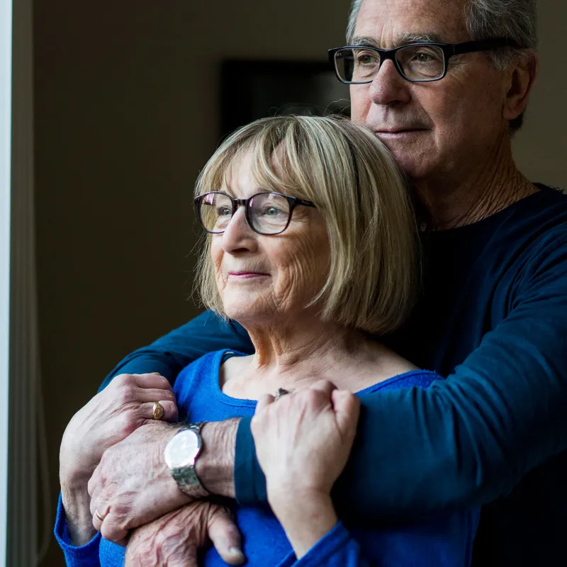 Husband holds her wife from behind