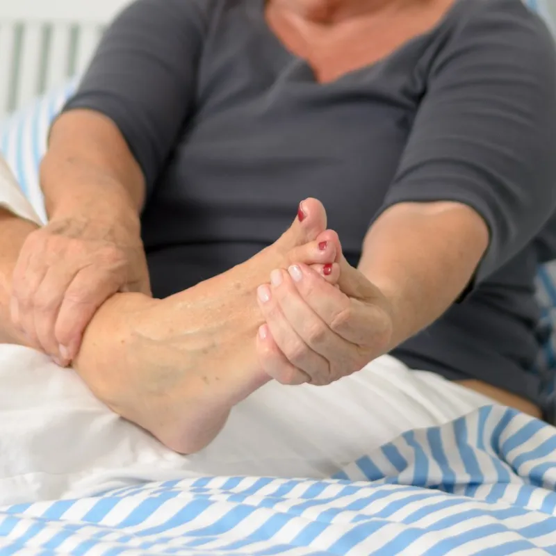 A senior woman massages her foot