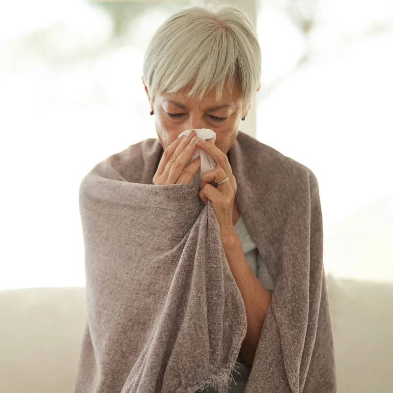 a woman blows her nose