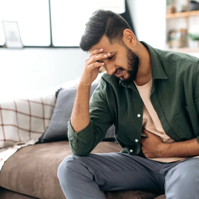 A sick man holding his forehead in his hand