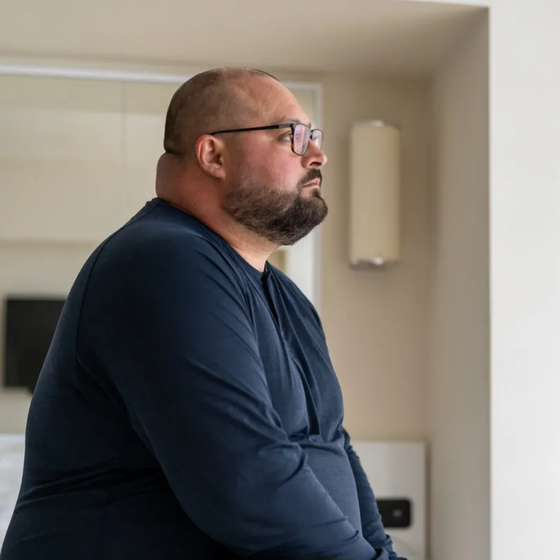 A man sitting at home looking onward.