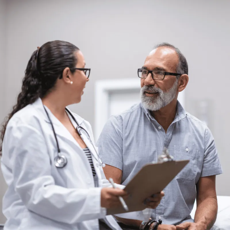 A middle-aged man talking to a female doctor.