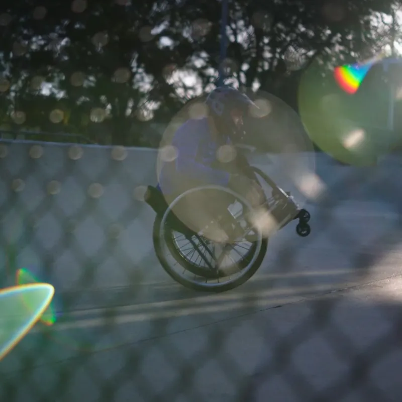 Man in a wheelchair doing a wheelie
