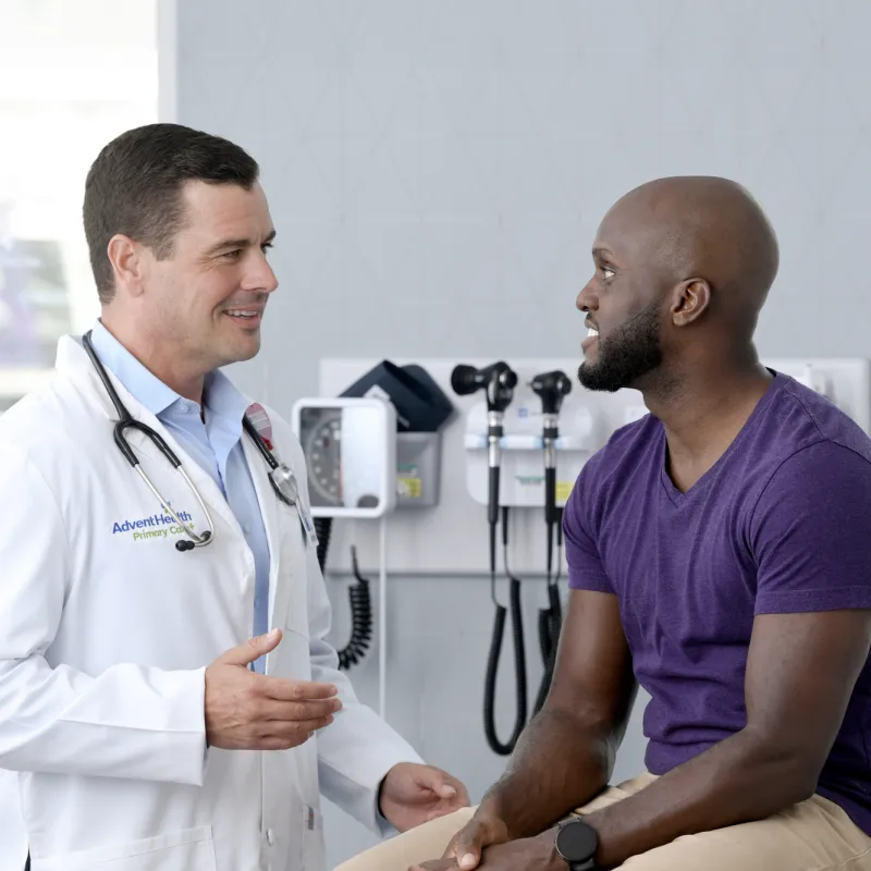 A Physician Speaks to His Male Patient in an Exam Room
