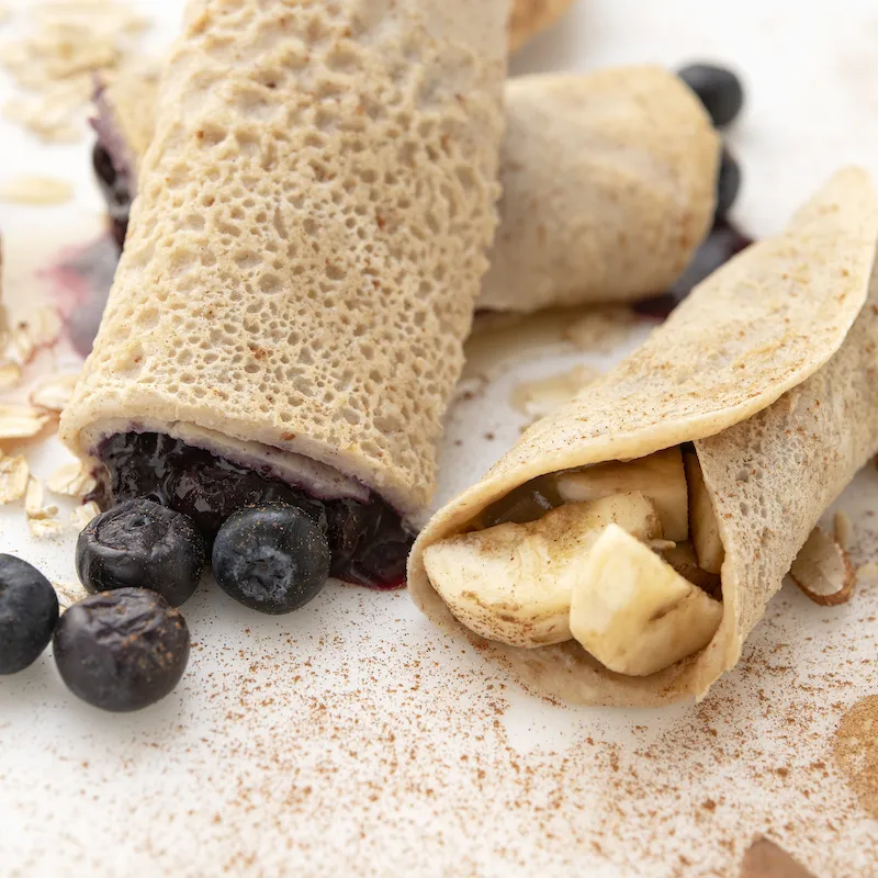 Two crepes filled with blueberries, one crepe filled with potatoes