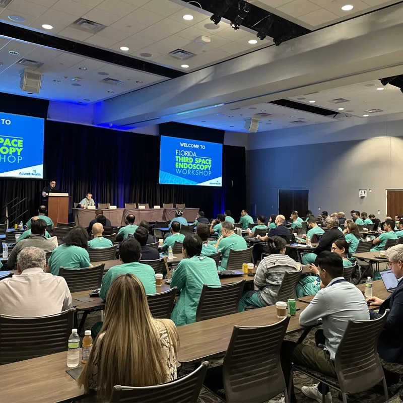 A room full of people watching a presentation.