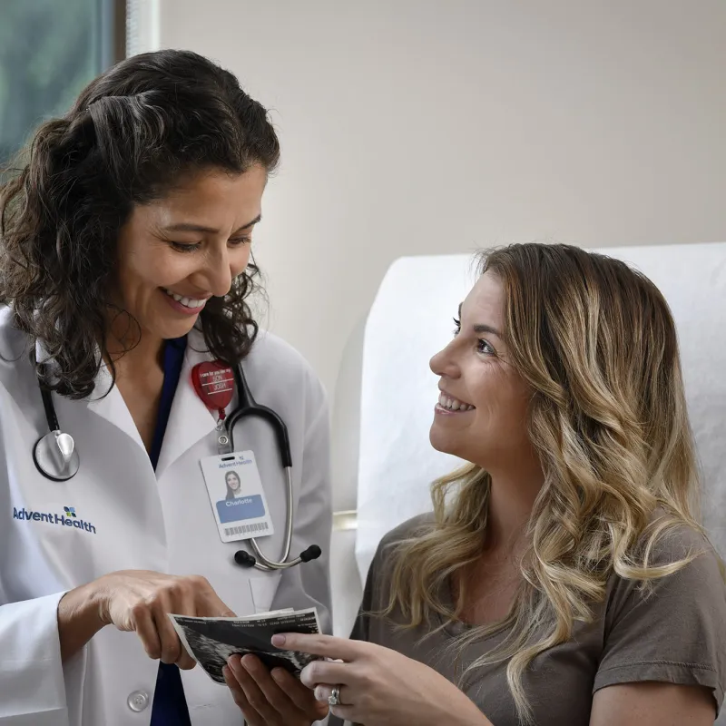 Young Woman talking to her doctor in a patient room.
