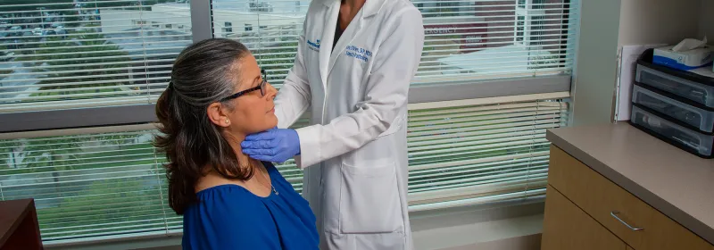 Doctor Cory O'Brien examining patient's throat.