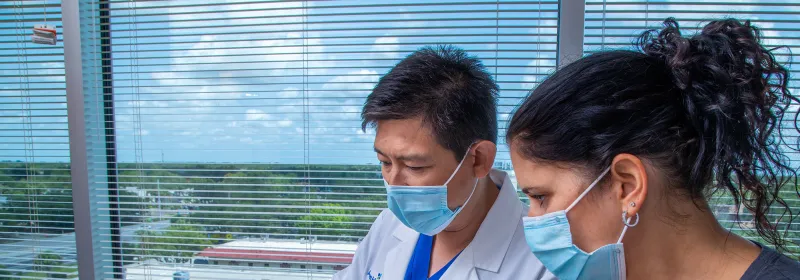 Iswanto Sucandy showing patient a something on a laptop.