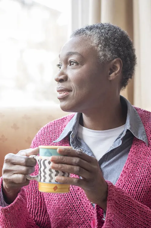 Enjoying her morning coffee, a mature woman reflects on life.