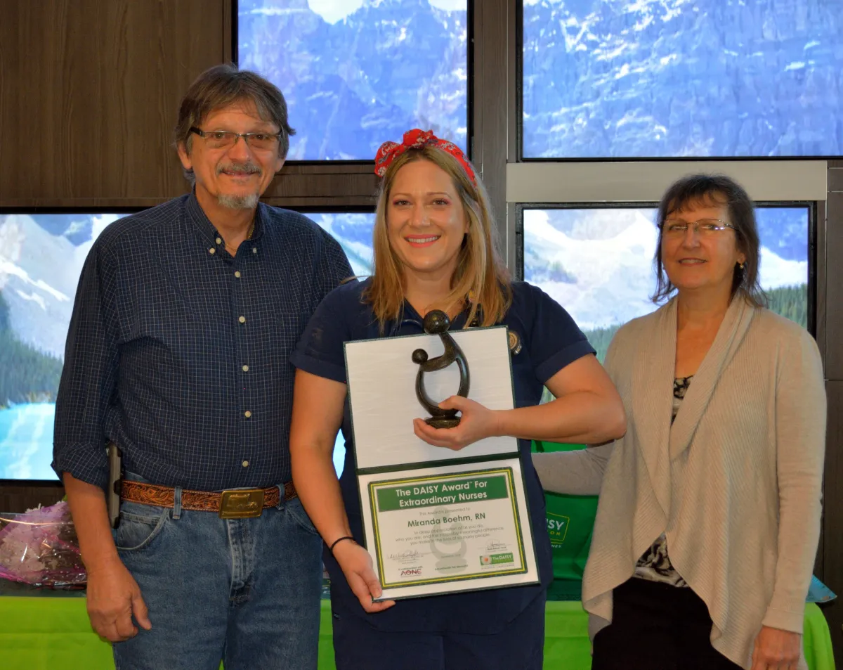Miranda Boehm, a registered nurse at AdventHealth Fish Memorial, received the DAISY award, an international program that rewards and celebrates extraordinary clinical skill and compassionate care provided by nurses. Pictured here: Boehm (center) stands with her parents Robert and Christine Young.